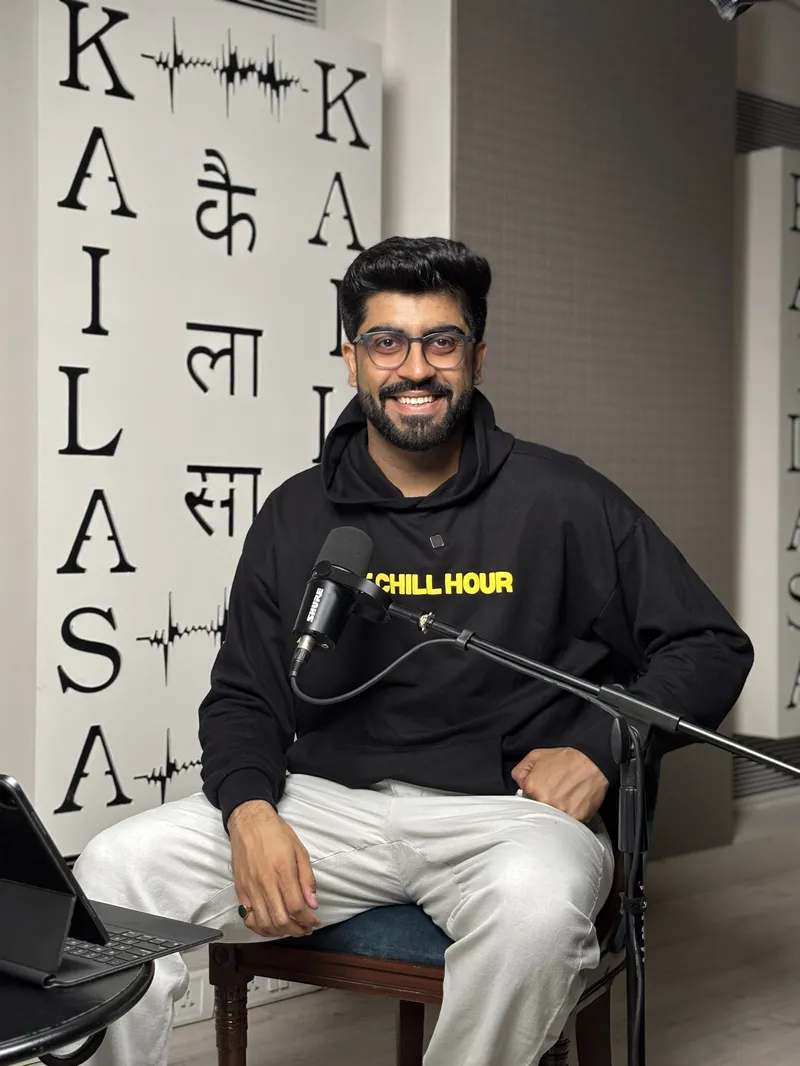Deepak Pareek seated with a microphone in The Chill Hour studio, wearing a black hoodie with the show name.