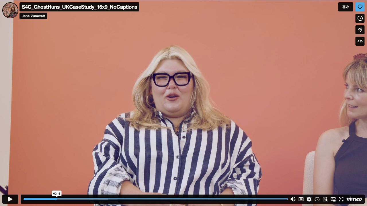 Official interview at 18.52 seconds: the host in stripes fills most of the frame, with the second host partly visible on the right.