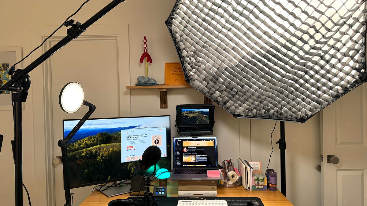Lenny Rachitsky’s published podcast studio photograph, showing a desk, microphone, screens and a large softbox light.
