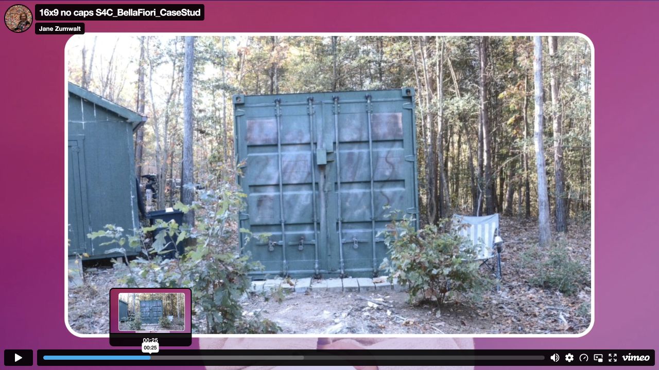 Official interview paused at 00:25, showing a closer photograph of a shipping container among trees.
