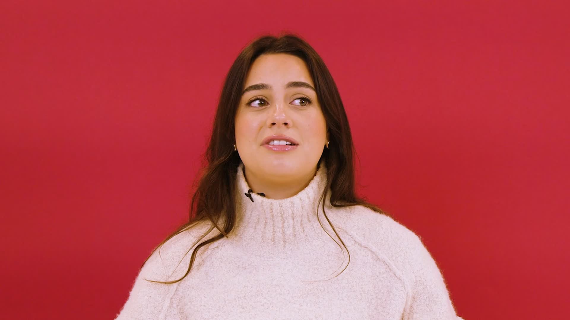 Bella Fiori in a cream sweater against a red background in the official Spotify case-study interview.